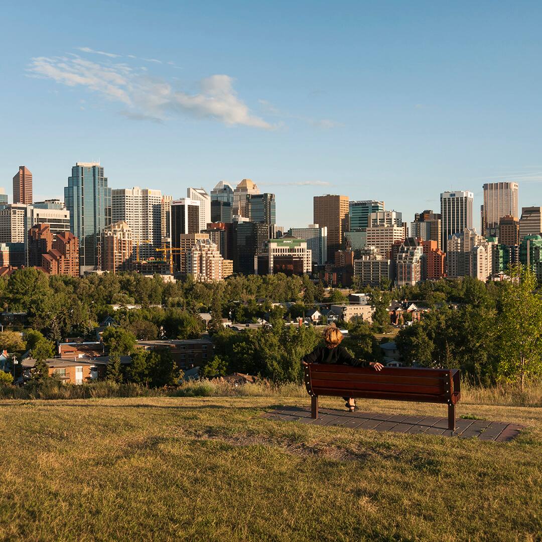 Calgary skyline with woman on bench