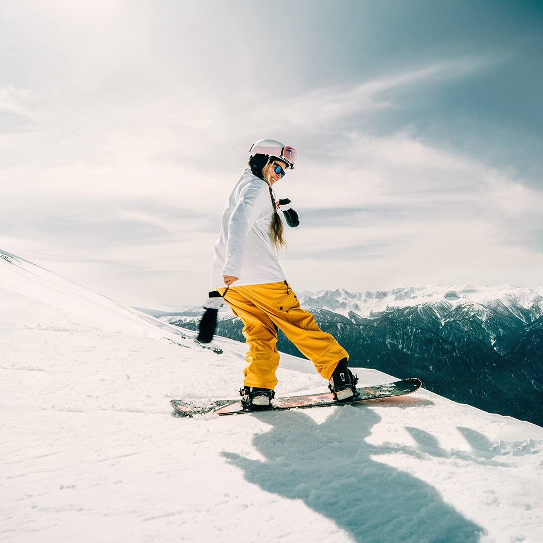 Snowboarder woman enjoying sunny day on mountain