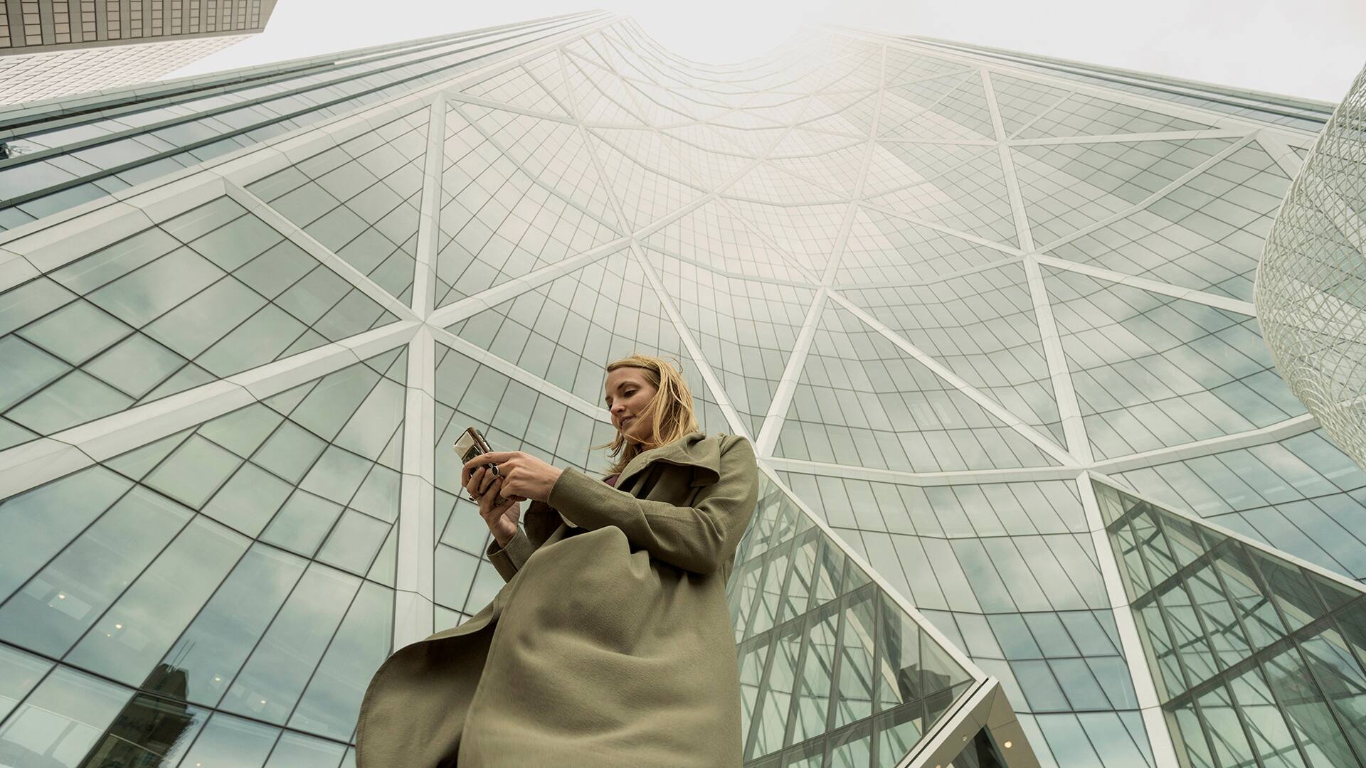 Woman sends text on smart phone, city center