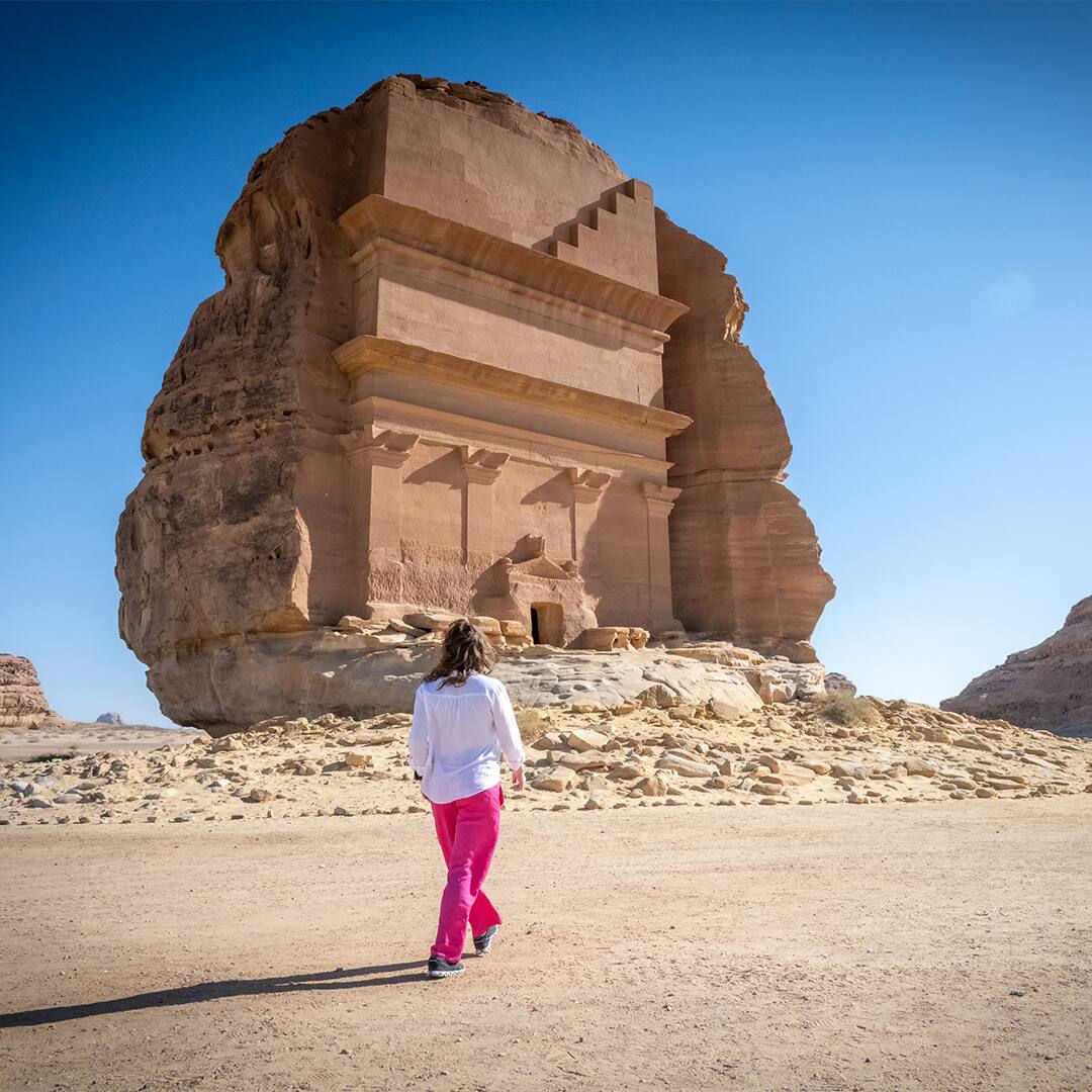 Young Caucasian woman in front Tomb Lihyan Son of Kuza or Qasr al-Farid at Hegra, Saudia Arabia