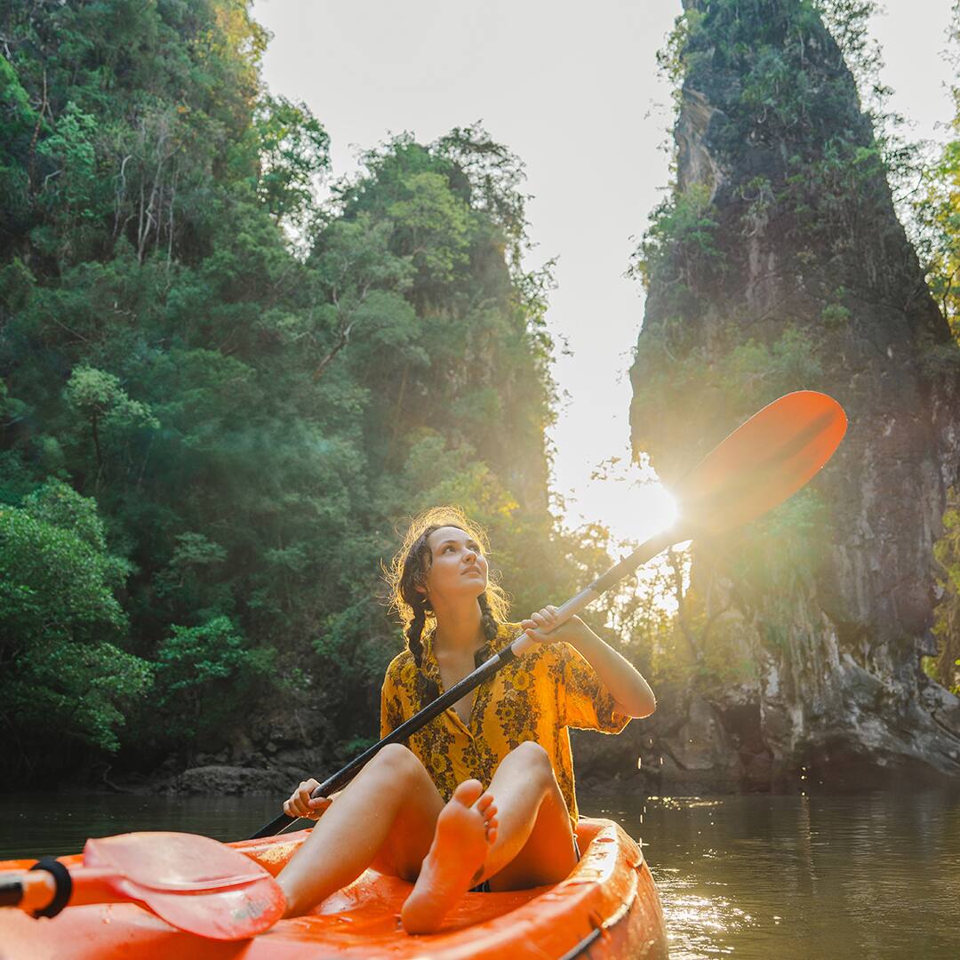 Young Caucasian woman sea kayaking among karst formations Krabi