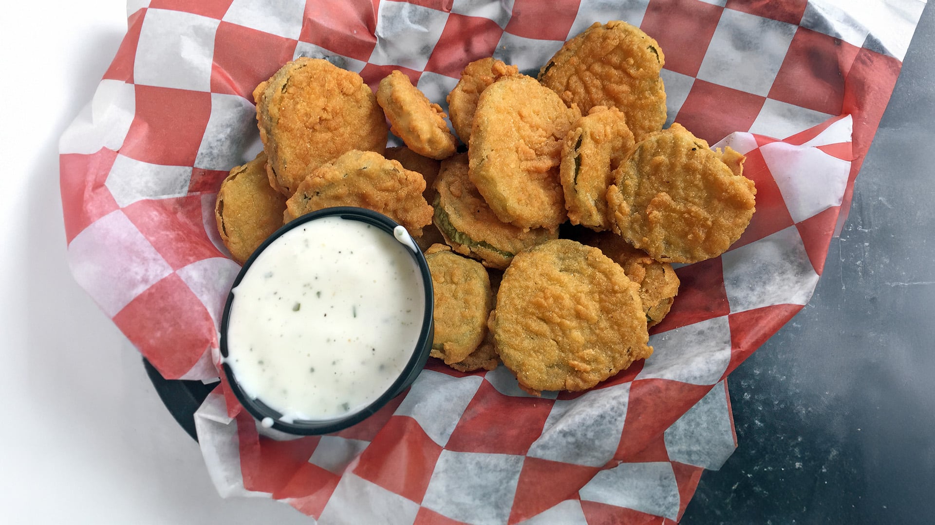 Fried pickles appetizer in a basket and ready to eat