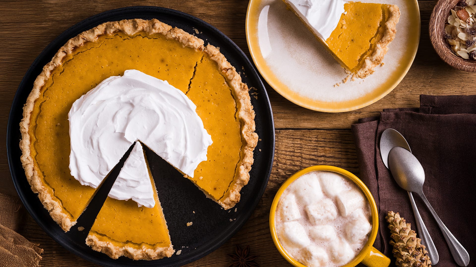 Thanksgiving Day pumpkin pie and mug of hot chocolate with marshmallows