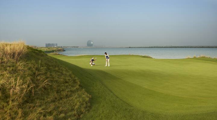 golfers playing golf in yas island's golf course