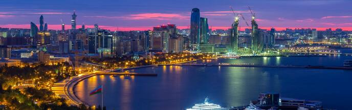 baku skyline at night showing skyscrapers against a bright sunset