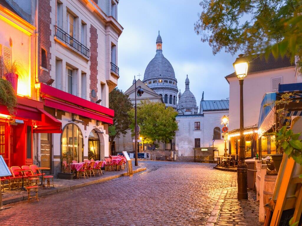 the place du tertre with cafe tables and the sacre coeur in the early morning in montmartre paris