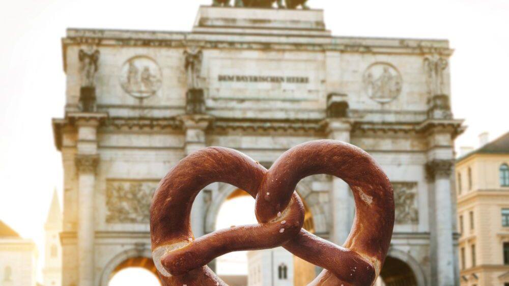 girl holding pretzel at the victoria gate arch siegestor in munich germany