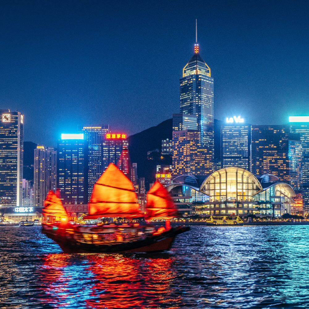 hong kong cityscape and junk boat at twilight