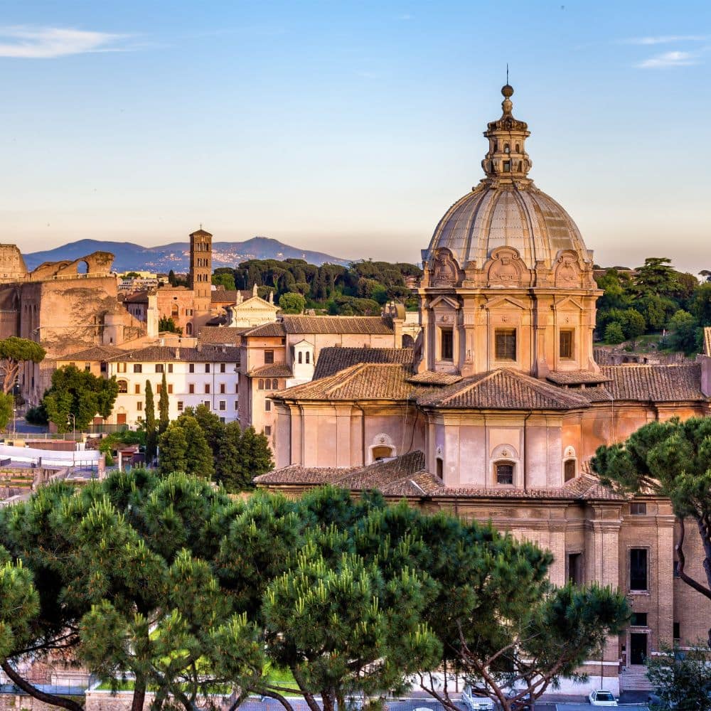a church surrounded by green trees and hills in the background rome italy