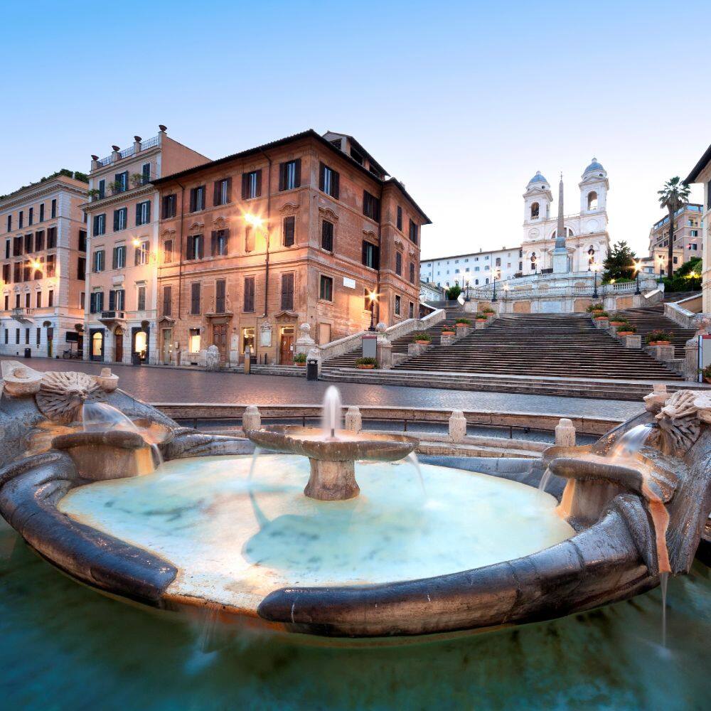 the piazza di spagna lit up at twilight in rome