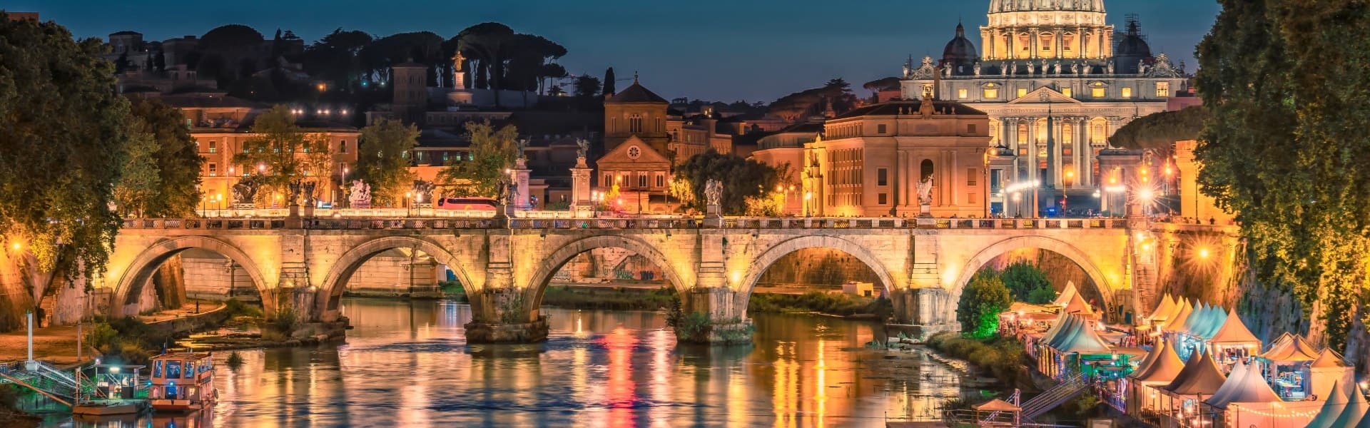 view of rome at night from the river with the buildings lit up italy