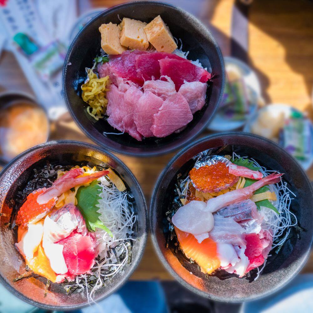 birds eye view of three bowls filled with seafood and noodles tokyo