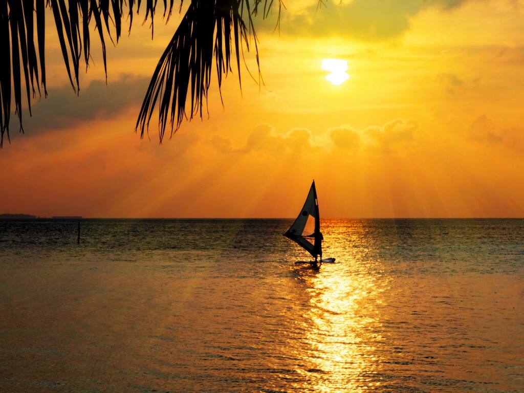 windsurfing at sunset in beautiful waters in the maldives