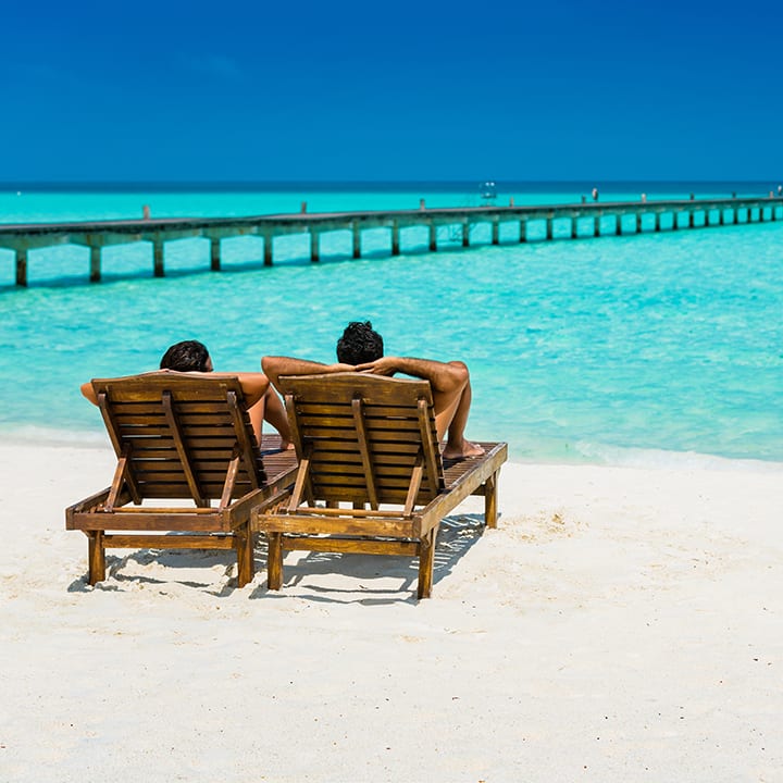 couple relaxing at a maldives beach 