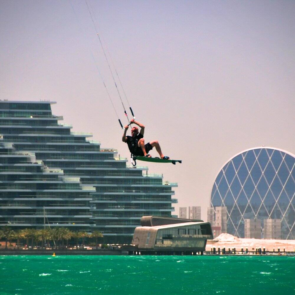 man kite surfing on a beach in abu dhabi