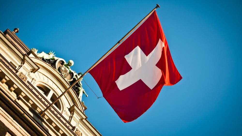 vibrant big red swiss flag on historic building in switzerland 
