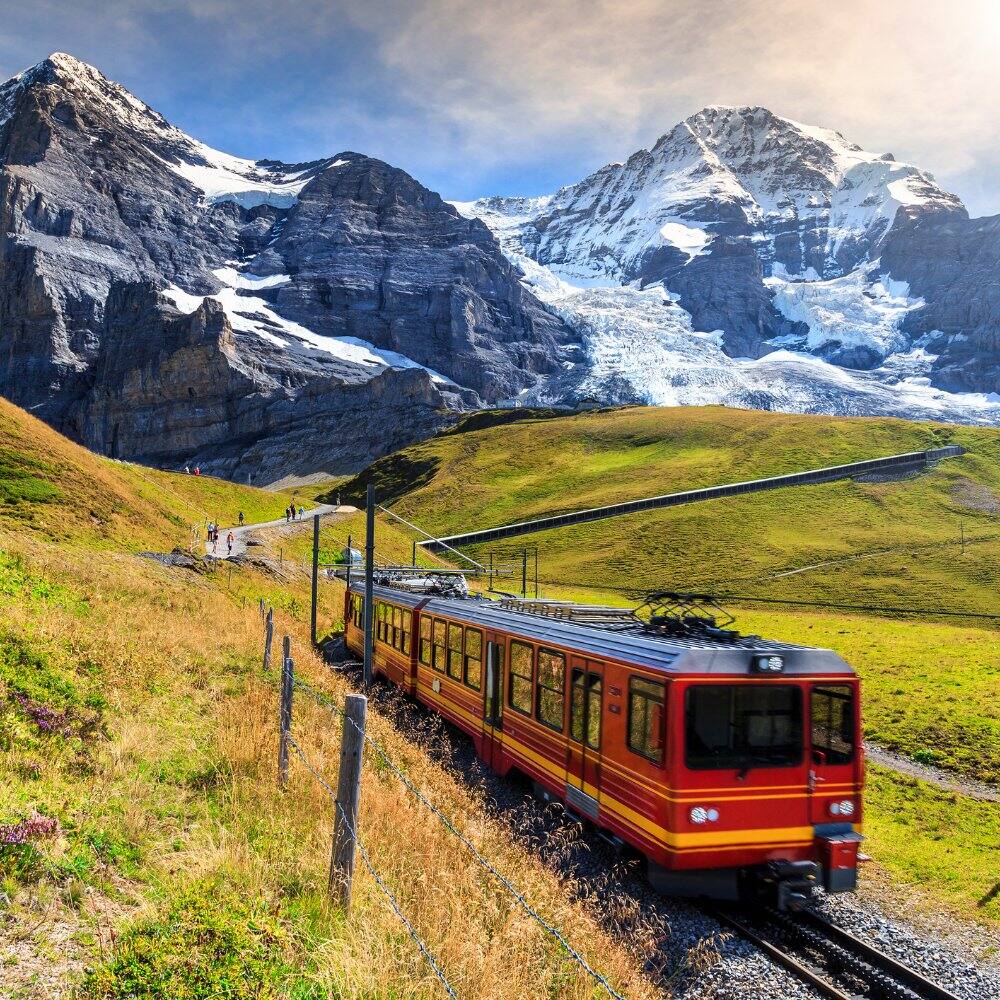 view of the alps and a train in switzerland