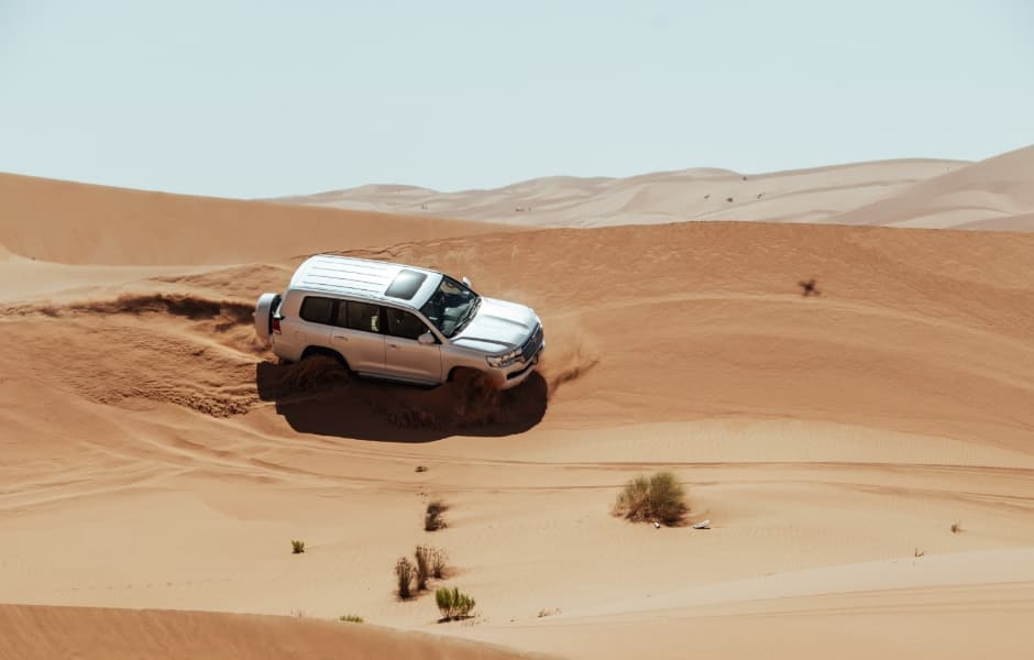 jeep driving through desert near abu dhabi