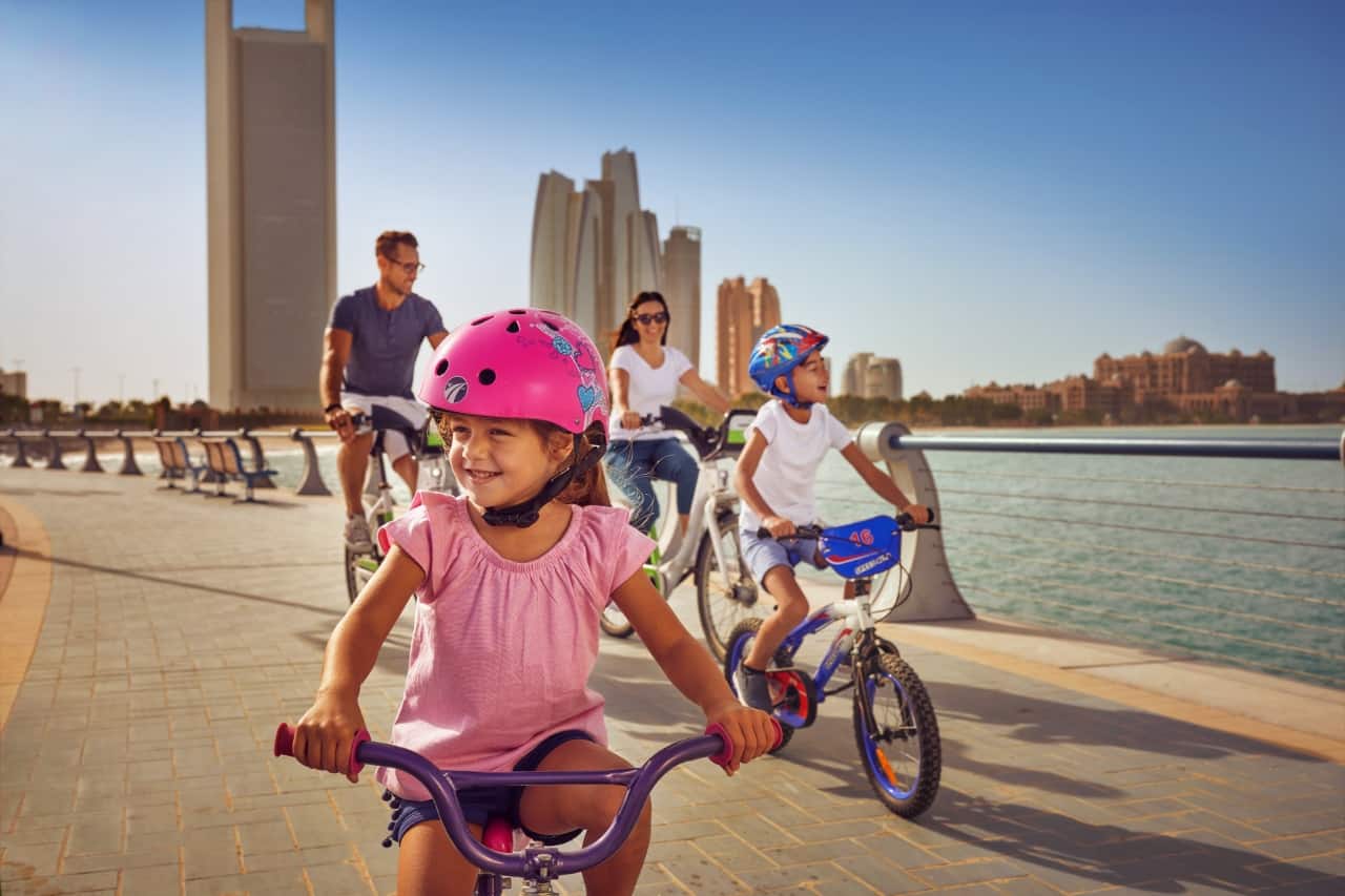 family cycling along corniche in abu dhabi