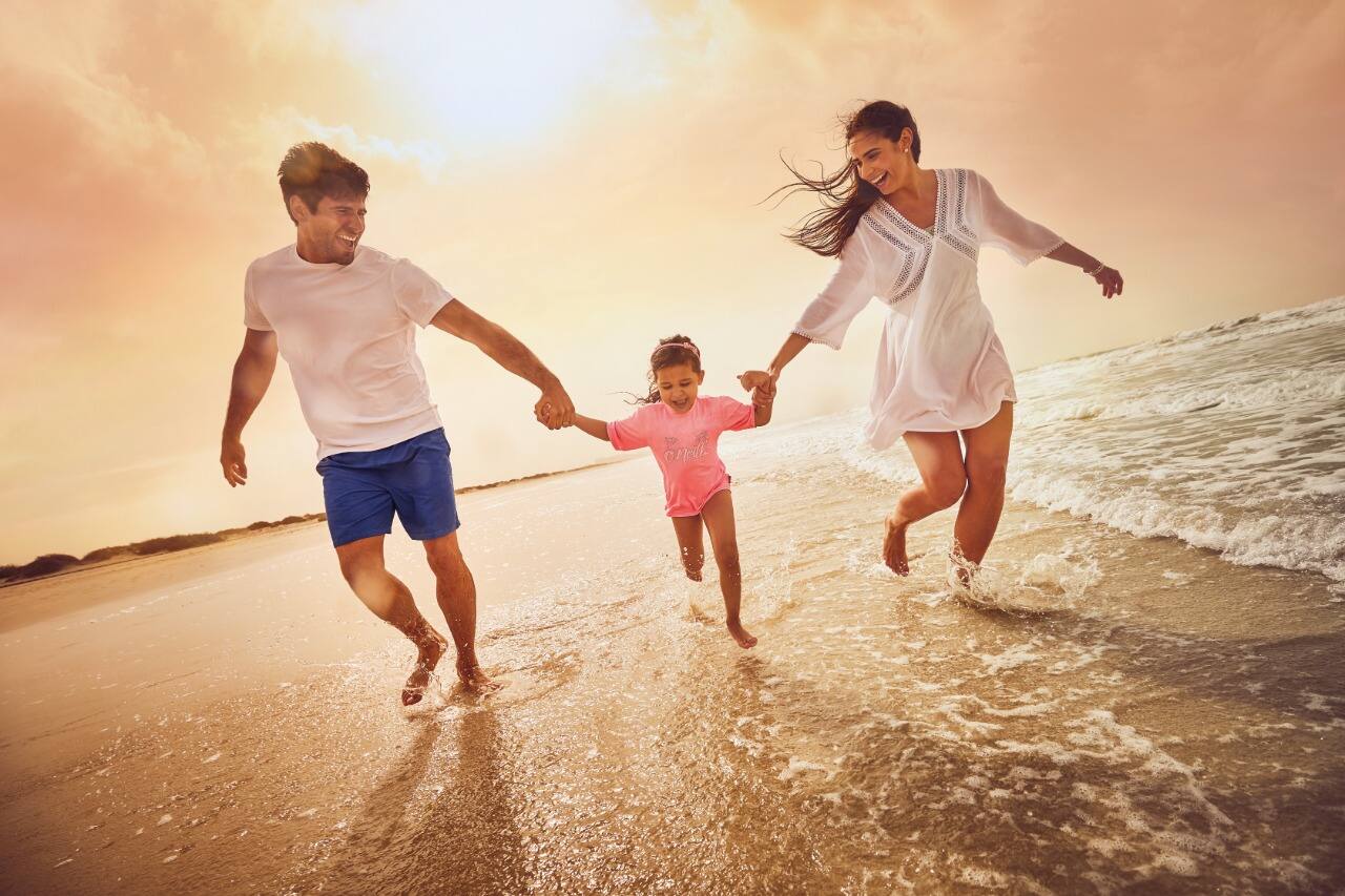 family running along beach in abu dhabi
