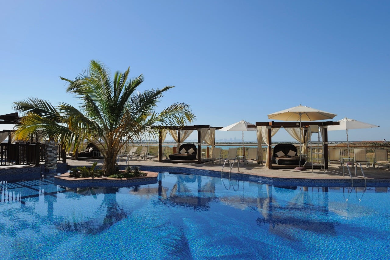 radisson blu pool with cabanas and palm trees
