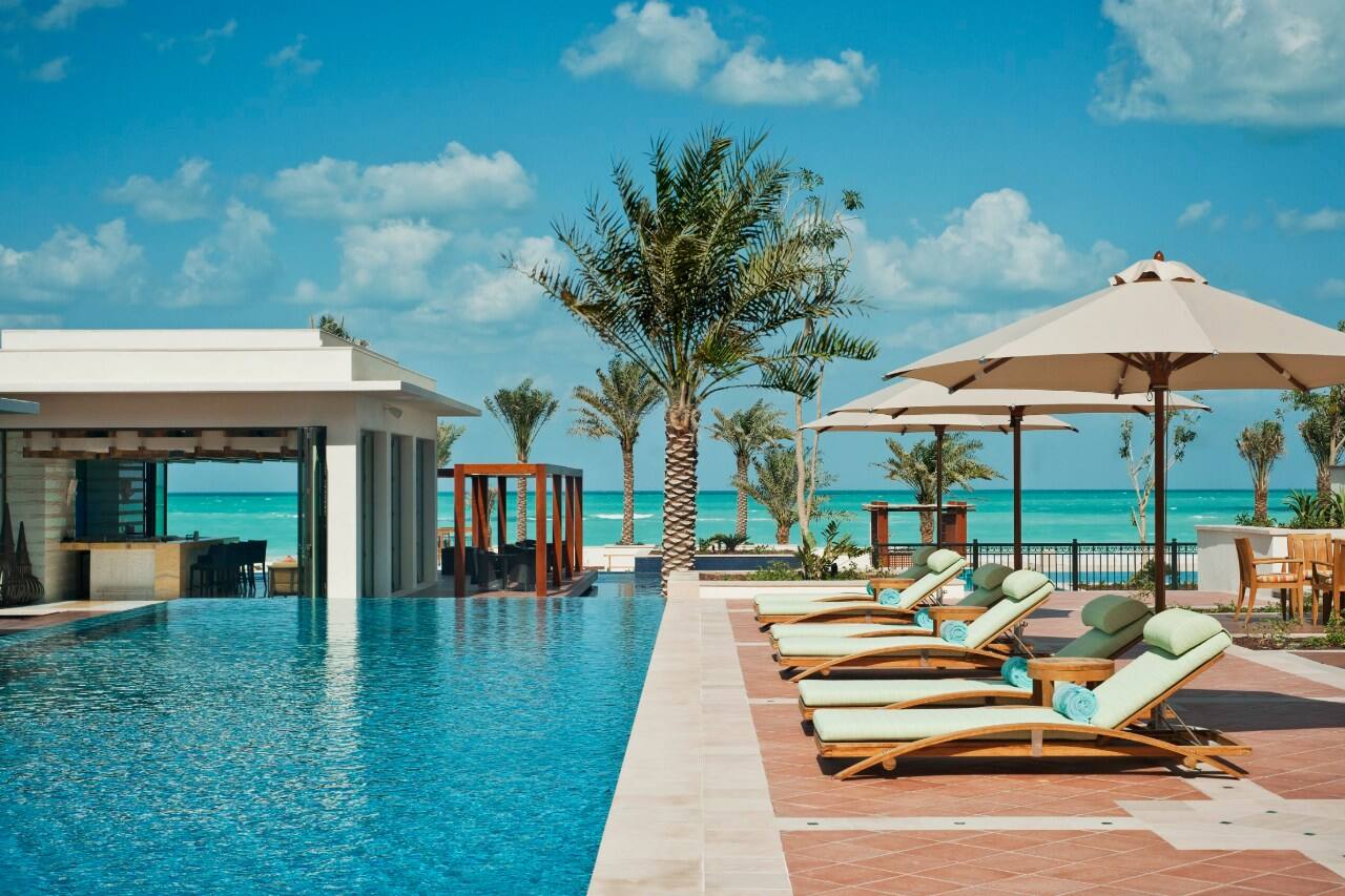 outdoor pool at st regis with sunloungers and parasols
