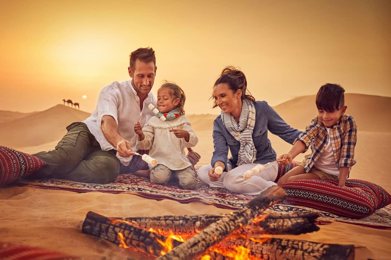 family enjoying a campfire desert abu dhabi