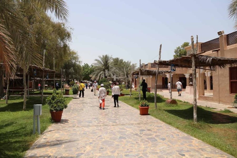 people walking on path through heritage village in abu dhabi
