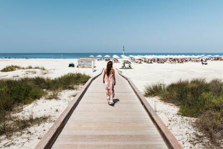 man and woman on boardwalk on saadiyat beach 