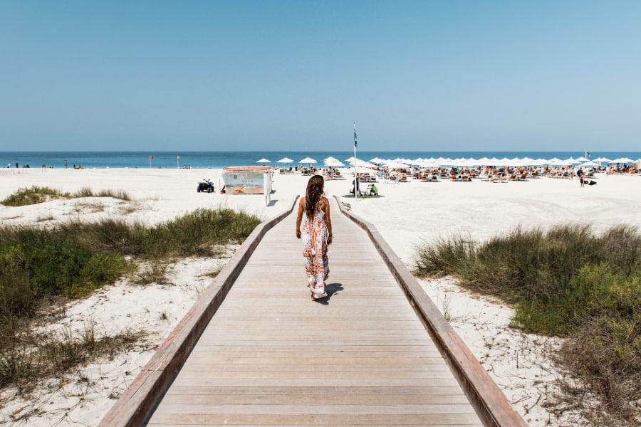 woman walking towards beach in abu dhabi