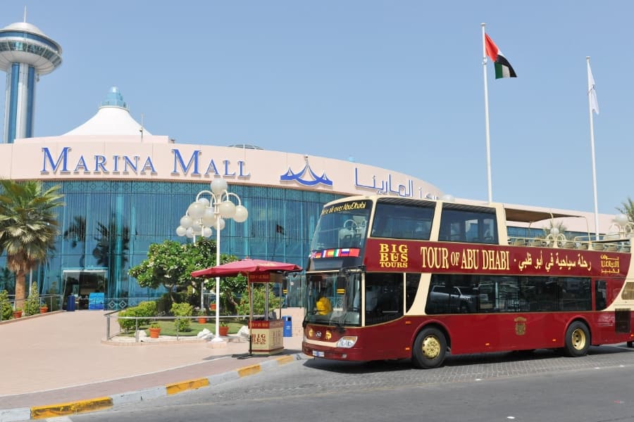city tour bus situated outside the marina mall