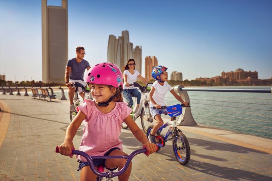 family cycling along corniche in abu dhabi