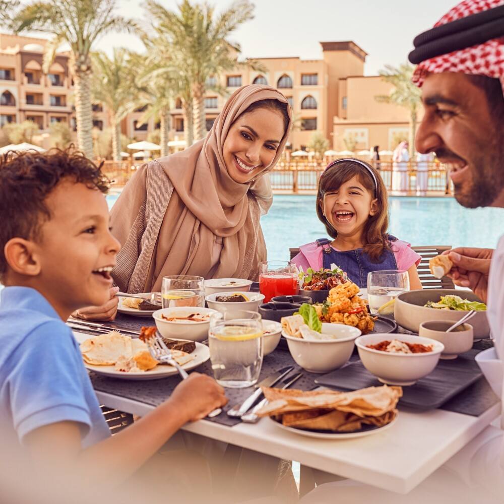 a family enjoying breakfast in abu dhabi outside the emirates palace  