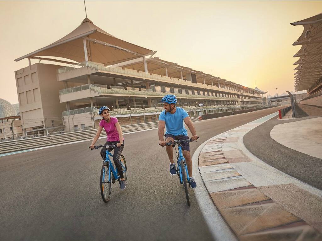 a couple cycling round the yas marina circuit in abu dhabi