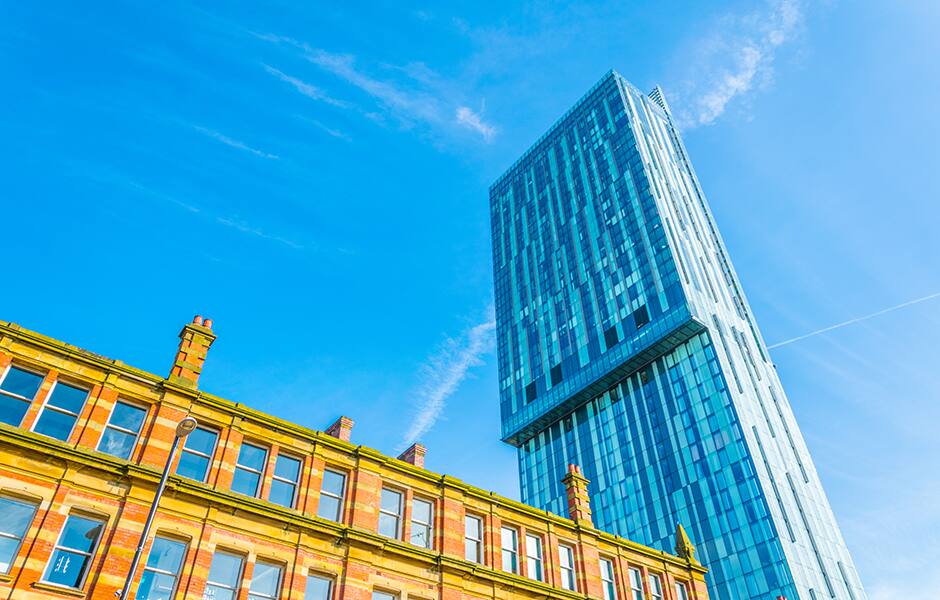 view of deansgate manchester with a mixture of old brick buildings and skyline