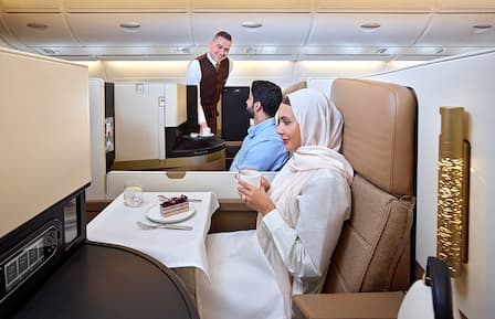 https://www.etihad.com/content/dam/eag/etihadairways/etihadcom/Global/products/onboard-cabins/business-class/business-couple-with-cabin-crew-serving-23.jpg?imwidth=432