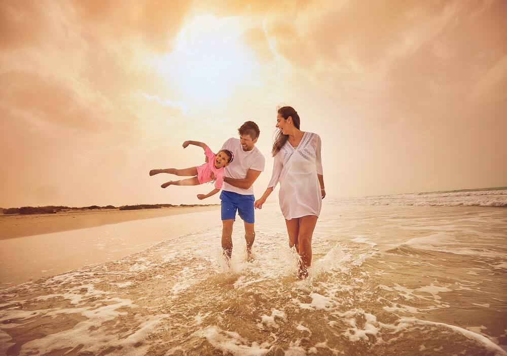 young family enjoying at the beach